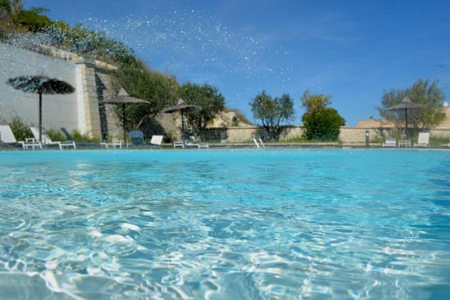 Una piscina all'aperto con spruzzi d'acqua.