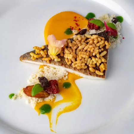 Filetto di pesce con riso soffiato e salsa arancione.