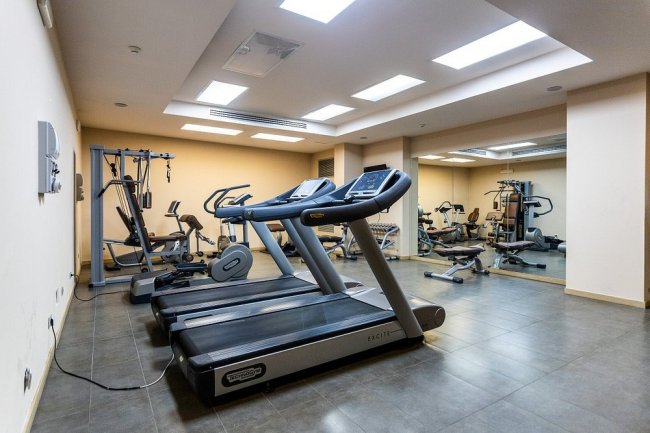 Palestra con tapis roulant e attrezzi vari.