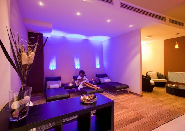 Sala relax con lettini e illuminazione blu soffusa.