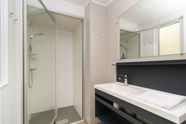 Bagno moderno con doccia e specchio.