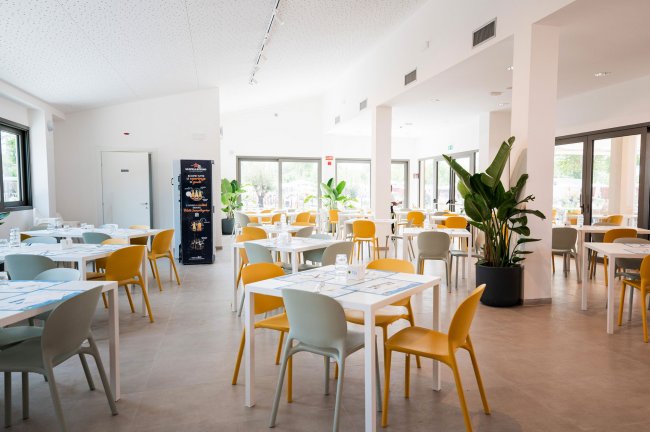 Ristorante luminoso con sedie colorate.