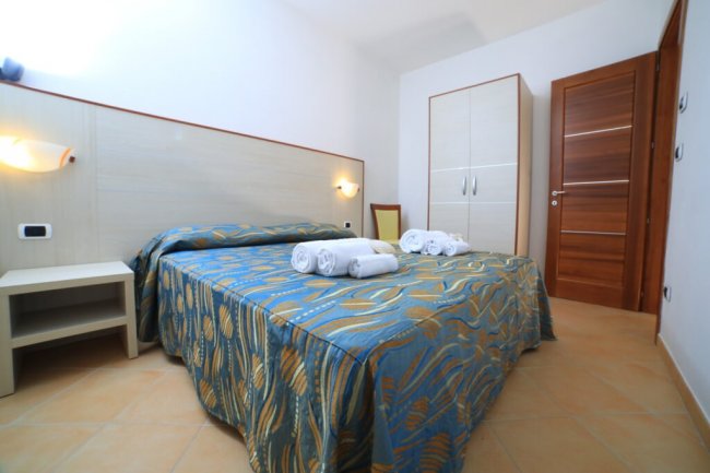 Camera da letto con letto matrimoniale e asciugamani.