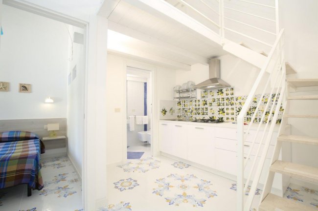 Cucina bianca con decorazioni floreali.