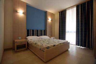 Camera da letto con letto matrimoniale e pareti blu e beige.