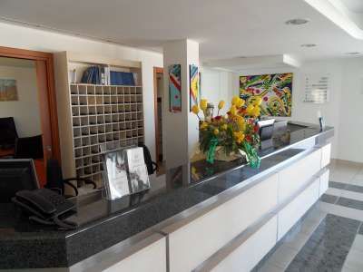 Un banco reception con un mazzo di fiori colorati e scaffali sullo sfondo.