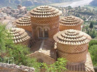 Un antico edificio con tetti circolari in mattoni e vista sul paesaggio.