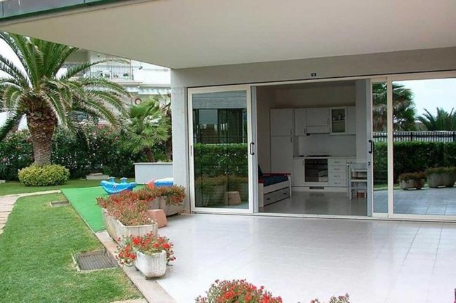 Patio con giardino e porte scorrevoli.