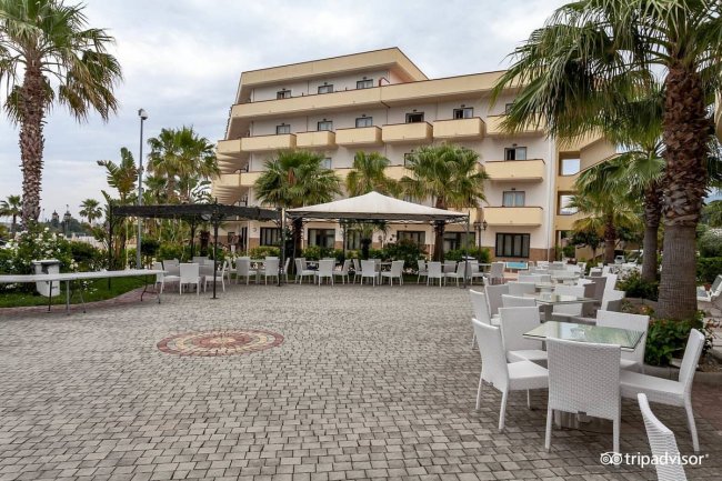 Area esterna con sedie e tavoli bianchi.