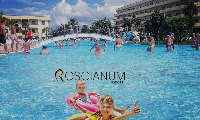 Persone nuotano in piscina con ponte.