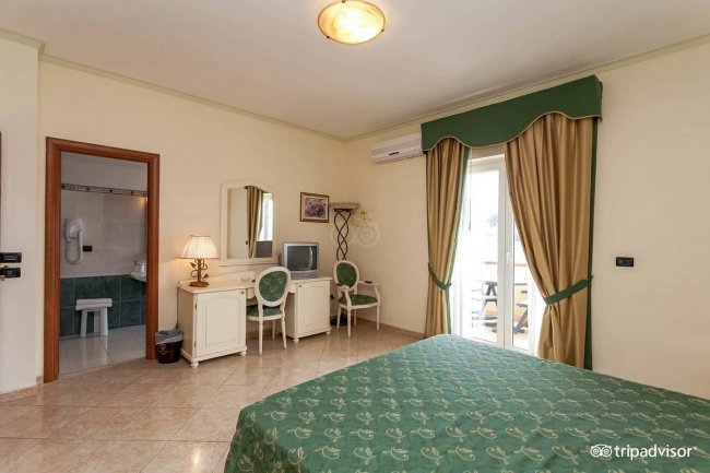 Camera d'albergo con letto e bagno.