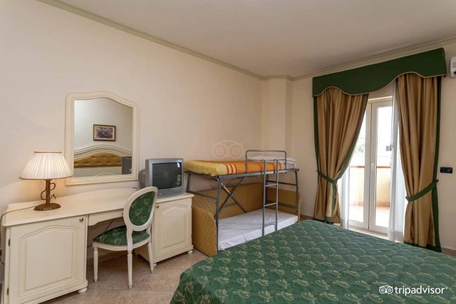 Camera con letto matrimoniale e lettini.