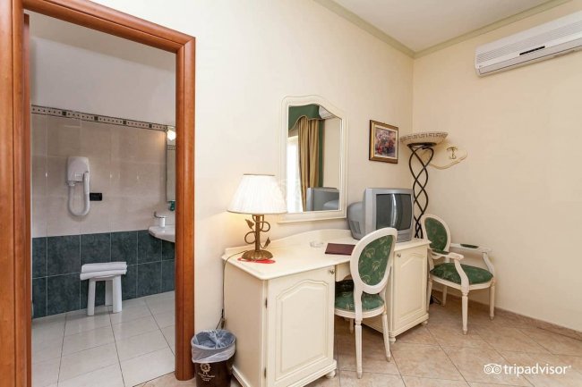 Camera con scrivania, specchio e TV.