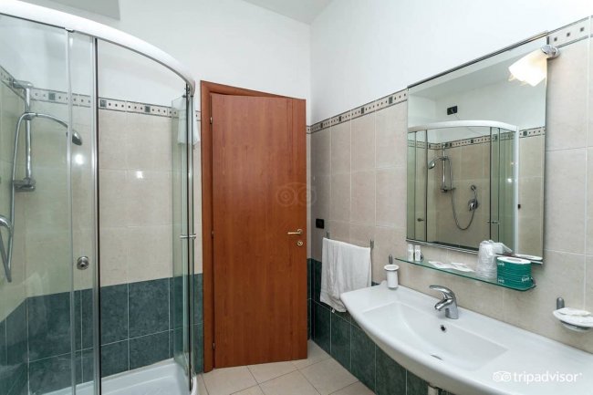 Bagno con doccia e ampio specchio.