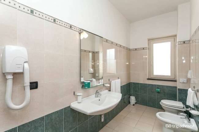 Bagno con vasca, specchio e bidet.