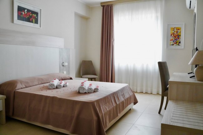 Camera da letto con letto matrimoniale e asciugamani piegati.