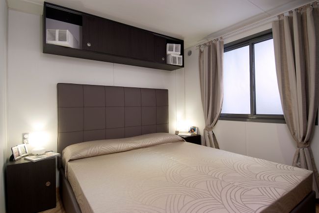 Camera da letto moderna con letto matrimoniale e mobili scuri.
