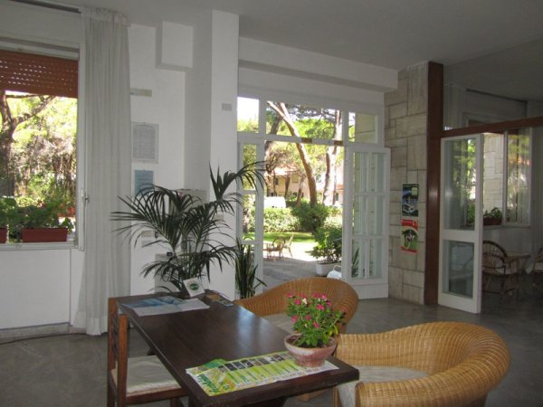 Angolo relax con poltrone in rattan vicino a finestre aperte.