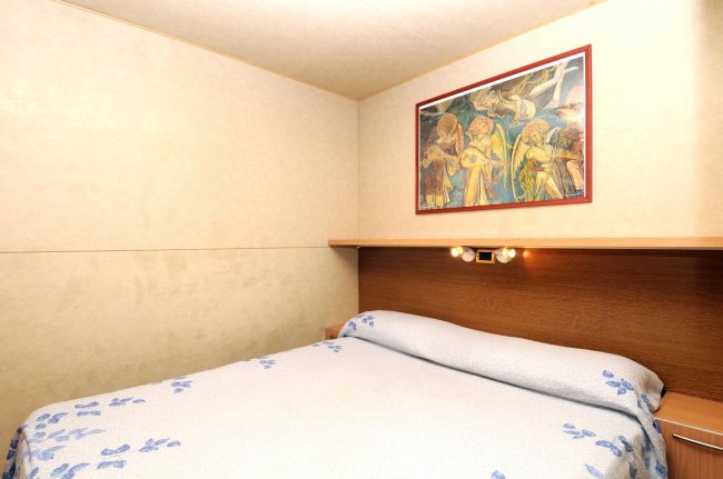 Camera con letto matrimoniale e copriletto blu.