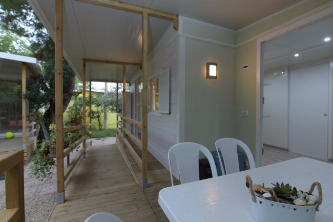 Veranda con tavolo bianco e sedie.