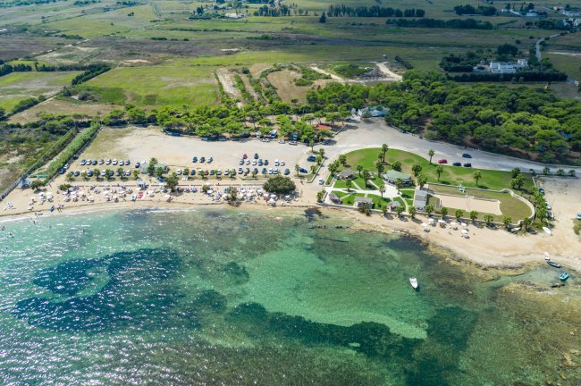 Vista aerea di una spiaggia e mare trasparente.