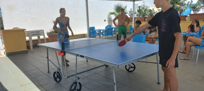 Persone giocano a ping pong all'aperto.