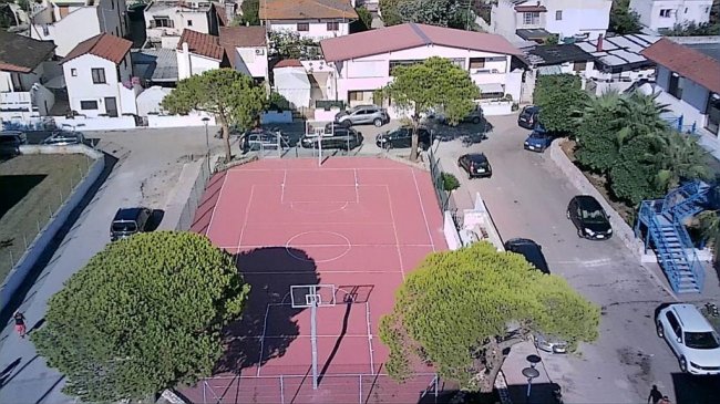 Campo sportivo all'aperto con canestro, viste dall'alto.