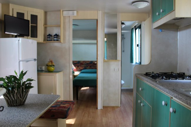Interno di una roulotte con cucina e tavolo.