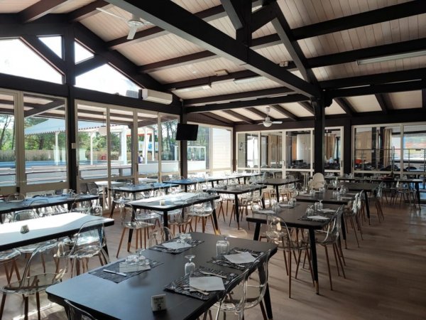 Sala ristorante con tavoli apparecchiati e vetrate.