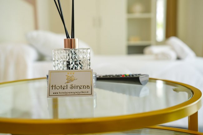 Tavolino con diffusore e cartello Hotel Sirena.