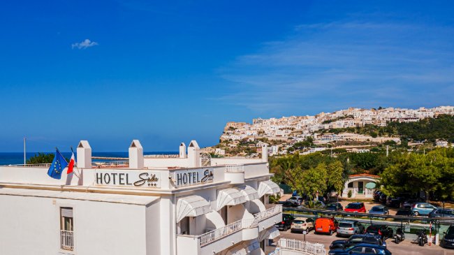 Vista dell'hotel con mare e città sullo sfondo.