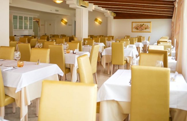 Sala ristorante con sedie gialle.