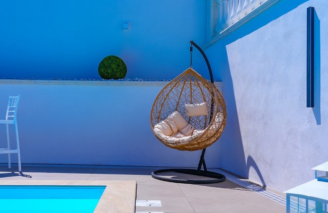 Poltrona sospesa e piscina in cortile.