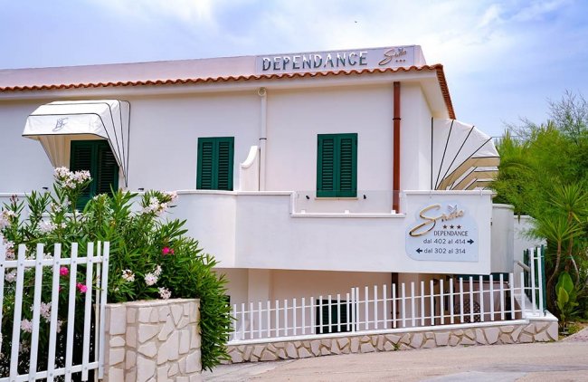 Edificio con balconi e piante verdi.