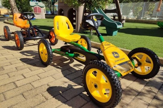 Kart giocattoli gialli su marciapiede.