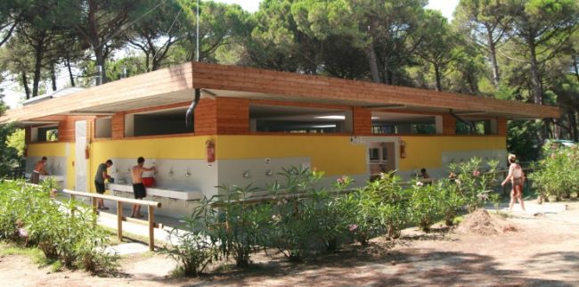 Edificio di servizi con persone all'esterno e piante.