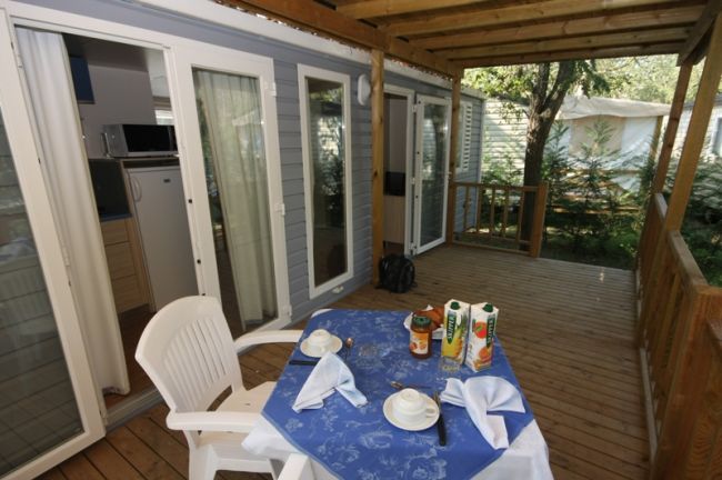Tavolo su veranda coperta, vista cucina interna.