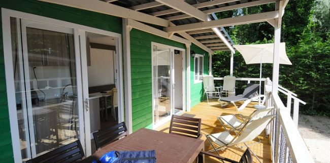 Terrazza in legno con lettini e tavolo da pranzo.