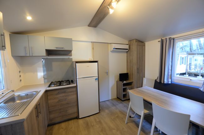 Cucina moderna con frigo, tavolo e divano.