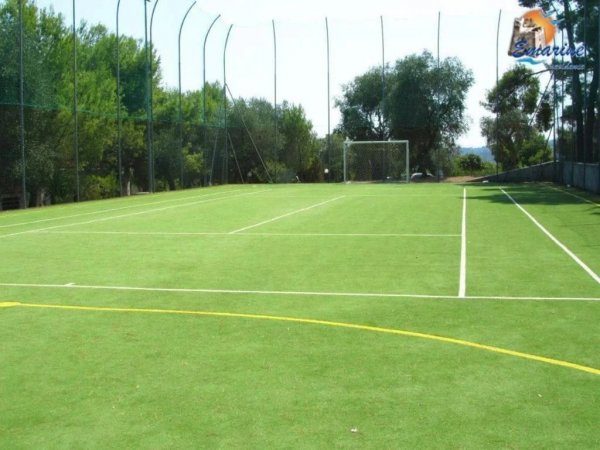 Un campo sportivo con erba sintetica e porte.