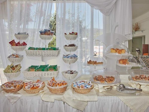 Esposizione di dolci e snack su tavolo bianco.