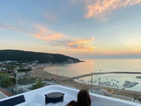 Vista della spiaggia al tramonto con vasca idromassaggio.