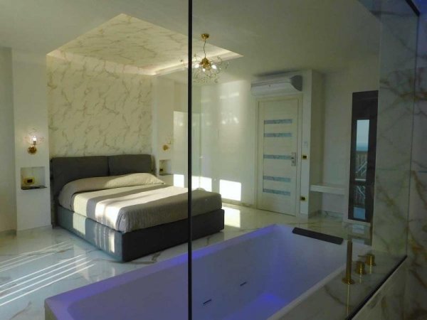 Camera con letto e vasca da bagno moderna.