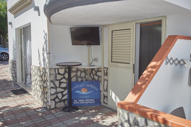 Ingresso con tavolo e targa del residence.