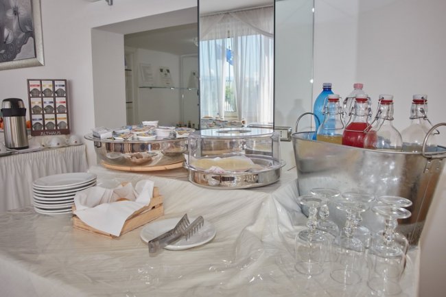Buffet con piatti, bicchieri e bevande.