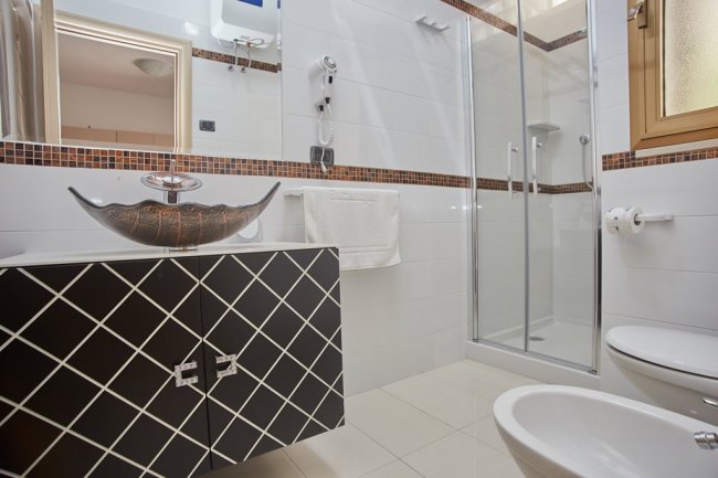 Bagno moderno con doccia in vetro.