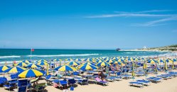 Mare con ombrelloni blu e gialli.