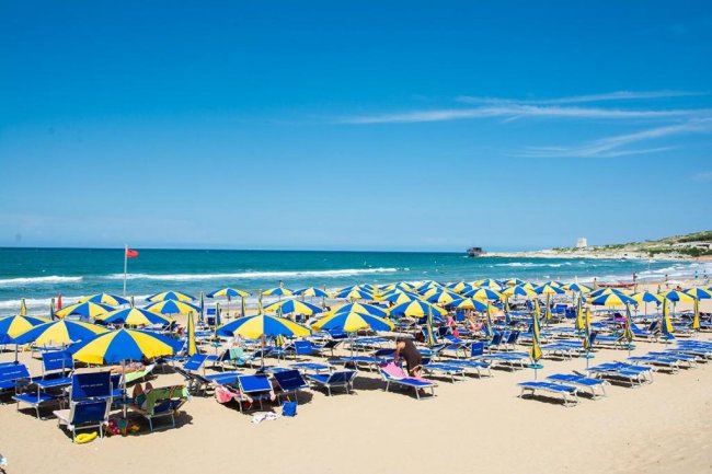 Spiaggia con ombrelloni gialli e blu.