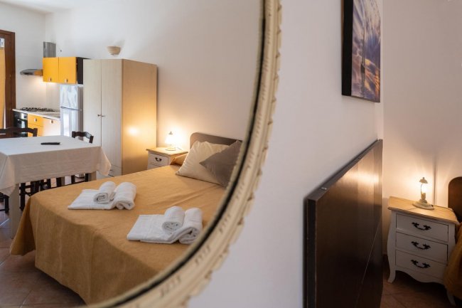 Camera riflessa in uno specchio, letto e cucina.