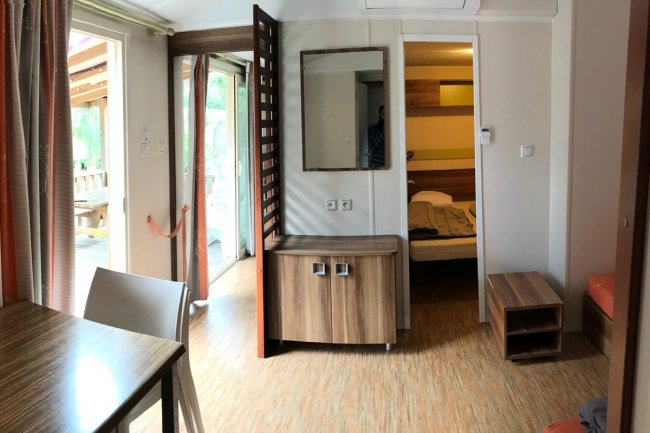 Interno di una casa mobile con camera e ingresso.